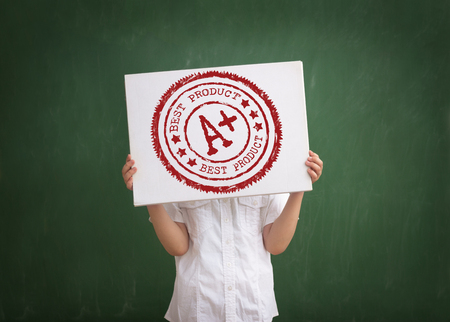 student shows his grade, holding a paper with a stamp A plus grade overheadの写真素材