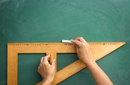 Student?s hands draw on the blackboard with a rulerの写真素材