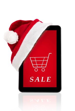 red Christmas hat  on tablet computer with Christmas sale on a screenの写真素材