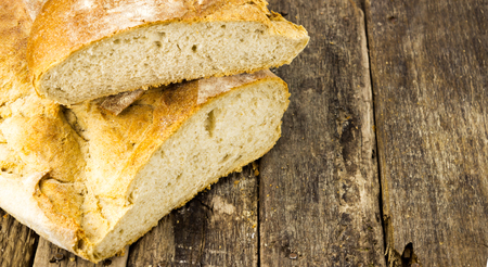 Cutting bread on wooden table with copy spaceの写真素材