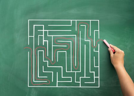 Problem and solution - person solving maze. Blackboard / chalkboard business concept.の写真素材