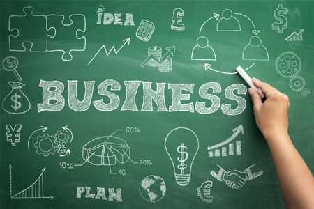 Hand drawn business icons set with arrows, diagrams and puzzle pieces on green chalkboardの写真素材