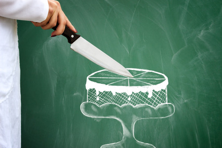Real female holding knife and cut sketching cakeの写真素材