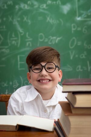 Happy nerd with glasses sitting at deskの写真素材