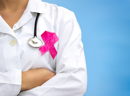 Doctor with ribbon formed Aids symbol, close-up, on color backgroundの写真素材