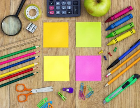 Colorful sticky notes with school items over wooden backgroundの写真素材