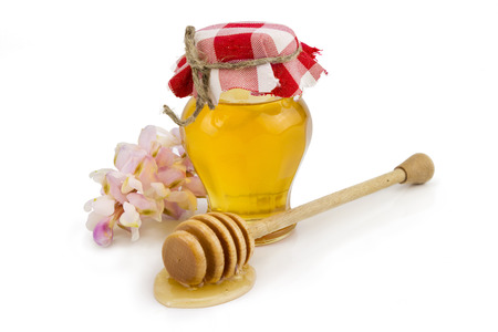 Honey jar with acacia flowers over whiteの写真素材