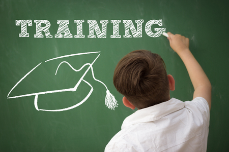 back view of little boy draw TRAINING on blackboardの写真素材