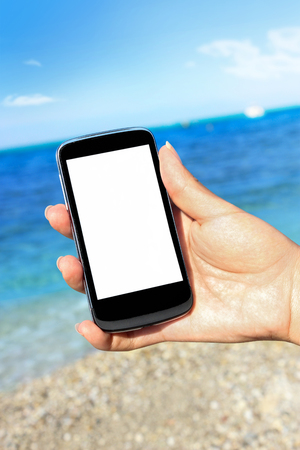 mobile phone with beach background, summer holiday and tourismの写真素材