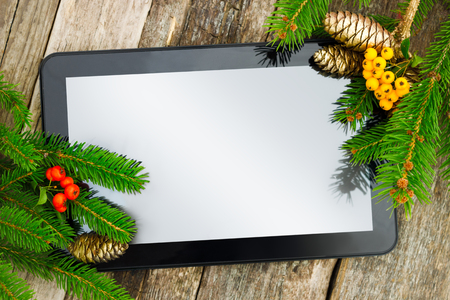 Tablet PC with Christmas decoration on wooden backgroundの写真素材