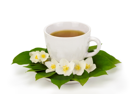 Cup of tea with jasmine flowers in plateの写真素材
