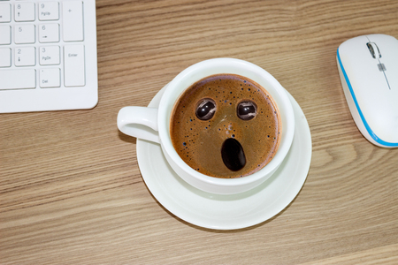 coffee cup with astonished expression in  in cream coffee, funny conceptの写真素材
