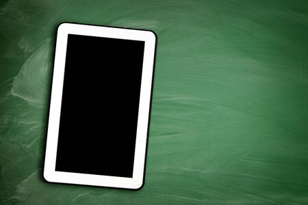 Tablet pc with empty screen on  and blackboard greenの写真素材