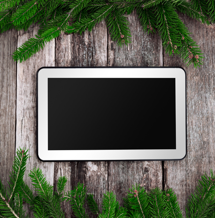 Blank tablet with Christmas decoration ornaments with pine treeの写真素材
