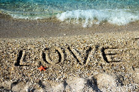 LOVE word draw on pebble at seacoastの写真素材