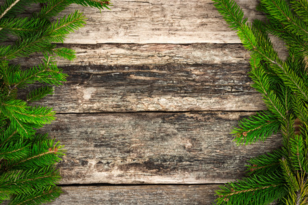 Christmas fir tree branches on wooden background, winter frameの写真素材