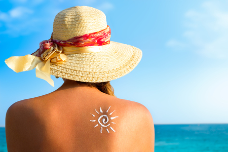 Suntan lotion woman with sunscreen solar cream over ocean backgroundの写真素材