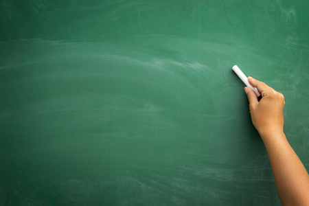 Blank blackboard / chalkboard, hand writing on green chalk board holding chalk, great texture for textの写真素材