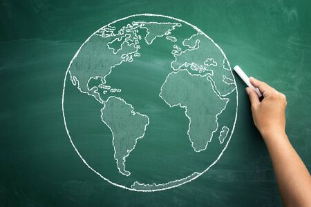 Close up of human hand drawing idea of global business on blackboardの写真素材