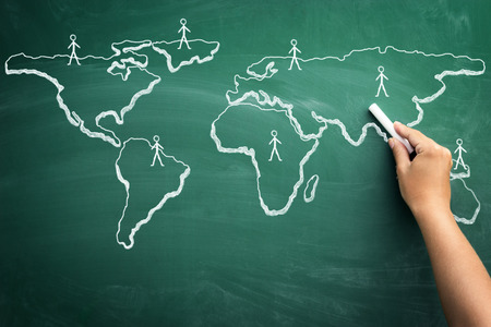 Close up of human hand drawing idea of global business on blackboardの写真素材