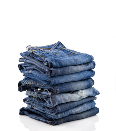 Lot of different blue jeans close-up isolated on whiteの写真素材