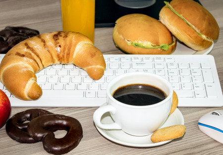 lunchtime in office, keyboard covered with food that we eat during workの写真素材