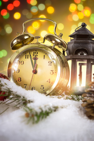 New Year's at midnight - Old clock with snow and holiday lightsの写真素材