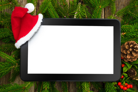 Digital tablet with Santa hat and Christmas decorationの写真素材