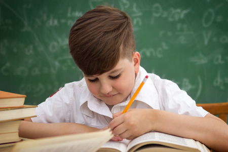 Little boy doing homework or writing during classの写真素材