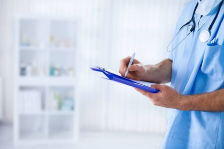 Young doctor writing medical resultsの写真素材