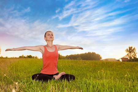 Woman meditating in nature with open armsの写真素材