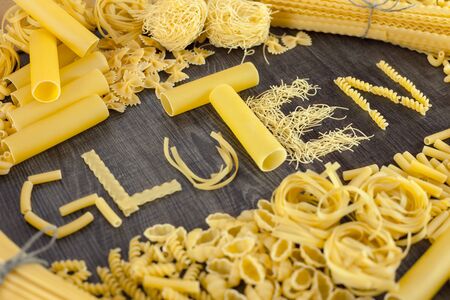 Shapes of pasta and gluten word made of pasta on wooden backgroundの写真素材