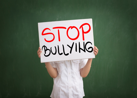 Young boy holding a sign with stop bullying textの写真素材