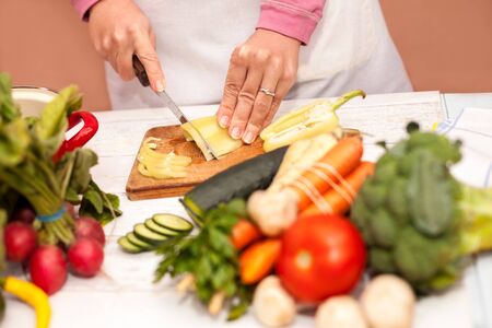 Woman cutting bell pepper on slices with a knifeの写真素材