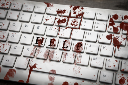 Bloody fingerprints on keyboard with word help, concept for danger and urgencyの写真素材