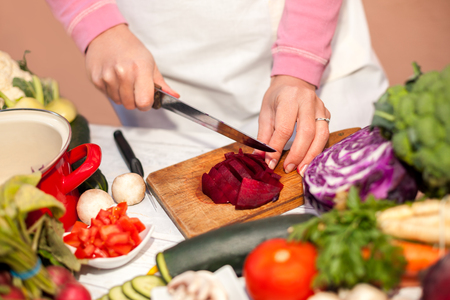 Cutting of beetroot with a knife on chopping board, vegetable cutting in the kitchenの写真素材