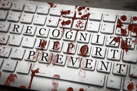 Recognize, report, prevent sign on bloody keyboard with bloody fingerprints, stop violence conceptの写真素材