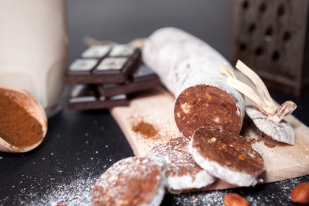Sausage from chocolate on chopping board on black table backgroundの写真素材