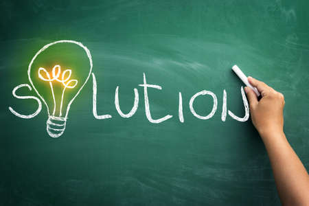 Solution is key of success ? bulb on blackboard like concept for solution, creativity, and innovationの写真素材