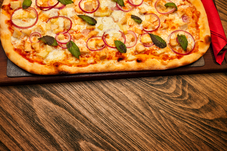 Hot pizza from the oven on the tableの写真素材