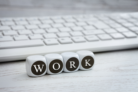 Letter dice with work text and white keyboard in the backgroundの写真素材