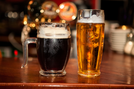 beer mugs , black and light bear on bar counterの写真素材