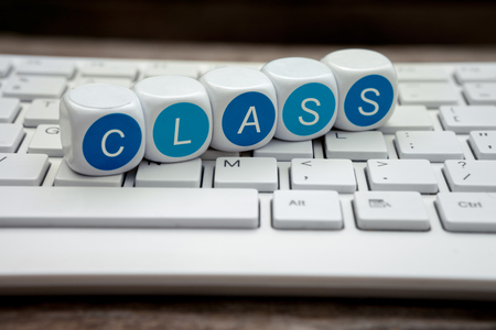 Letter dice with class text laying on keyboardの写真素材