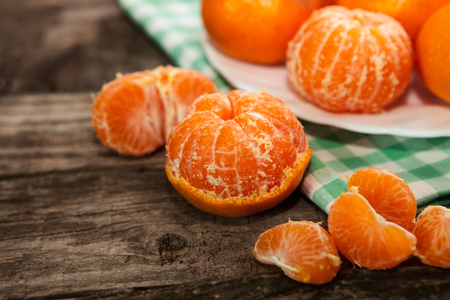 Peeled fresh clementines on wooden tableの写真素材