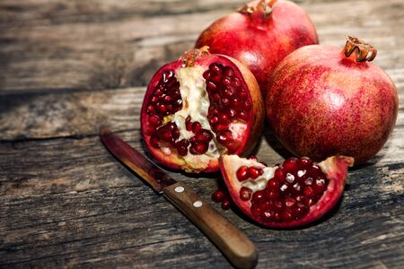 Ripe red pomegranate cut in half on wooden backgroundの写真素材