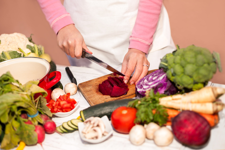 Woman with a knife cutting beetroot on chopping boardの写真素材