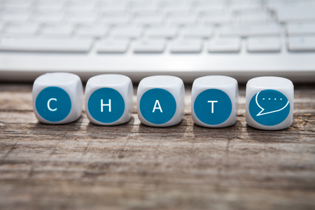 Letter dice with chat text and keyboard in the backgroundの写真素材