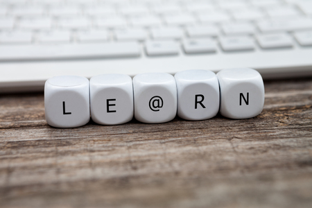 Letter dice with learn text and keyboard in the backgroundの写真素材