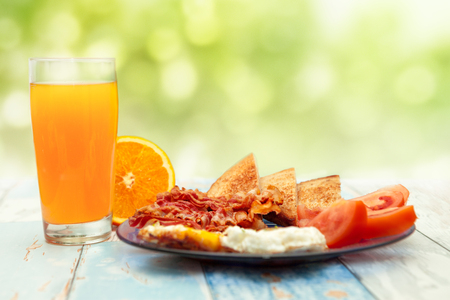Morning breakfast with fried eggs and orange juice on the tableの写真素材