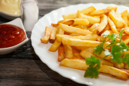 Close shot of french fries on a plate with tomato sauceの写真素材